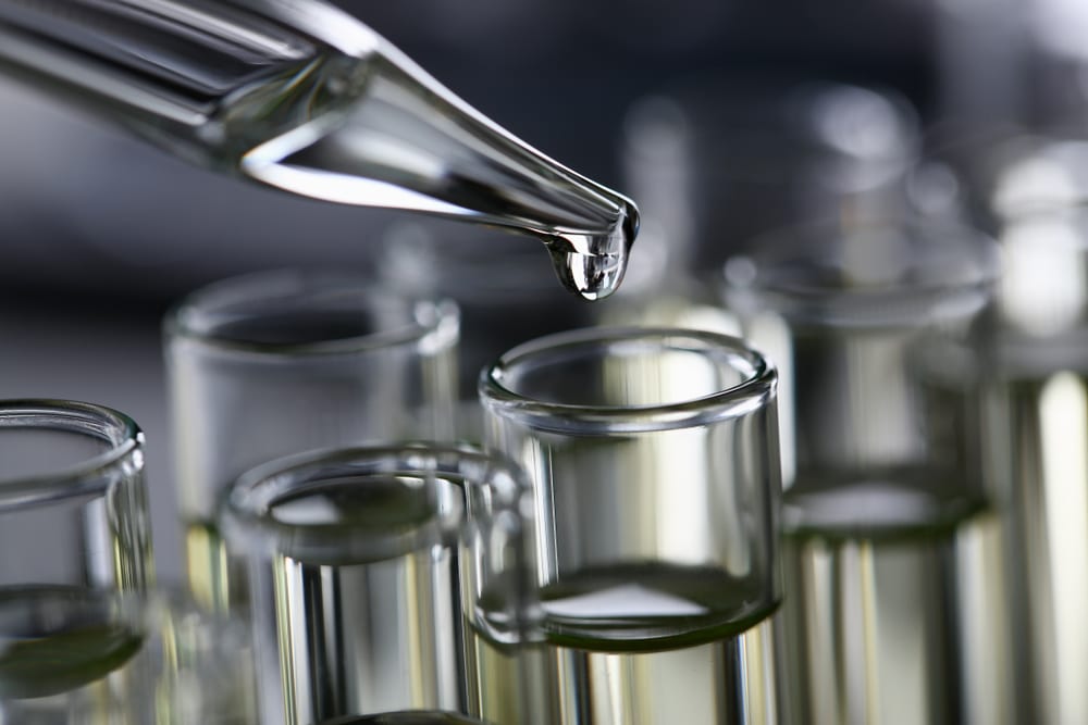 A pipette adding flavor extract to test tubes during supplement flavoring