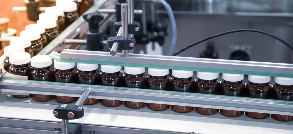 Bottles of finished capsule supplements moving down a bottling line