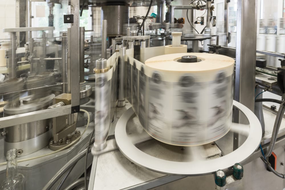 Label printing roll feeding through an automated bottle labeling machine