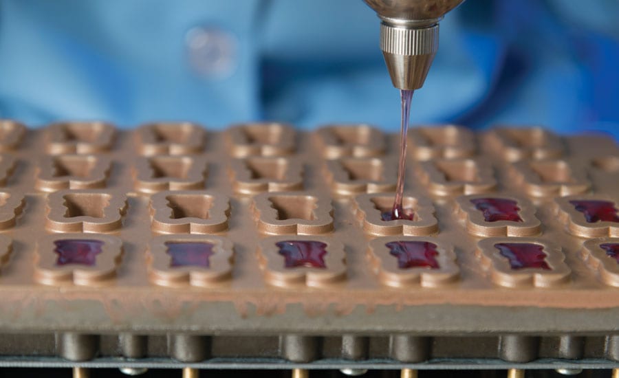 Gummy slurry being deposited into starch-coated molds