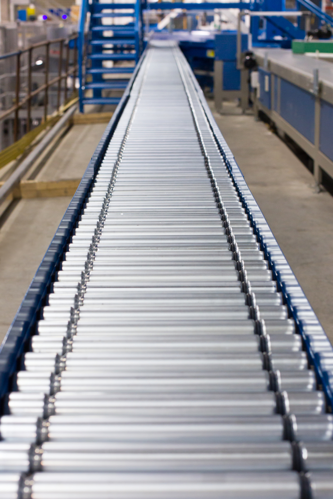 Conveyor line transferring softgel capsules to the tumble dryer
